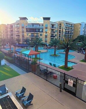 A hotel with a pool, outdoor seating, and a view of the surrounding buildings. - Stylish One-Bedroom Getaway Near Everything (Addison)