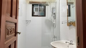 Ein Badezimmer mit Toilette, Waschbecken, Dusche und Spiegel.