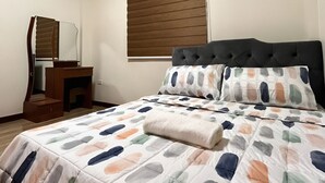 Ein Schlafzimmer mit Bett, Kommode, Spiegel und einem Fenster mit Jalousien.