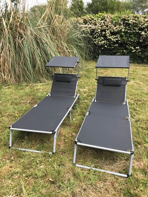 Two portable sunbeds in a grassy area with dense foliage in the background. - House with large garden, bike paths, bike beaches, pets welcome! (Les Mathes)
