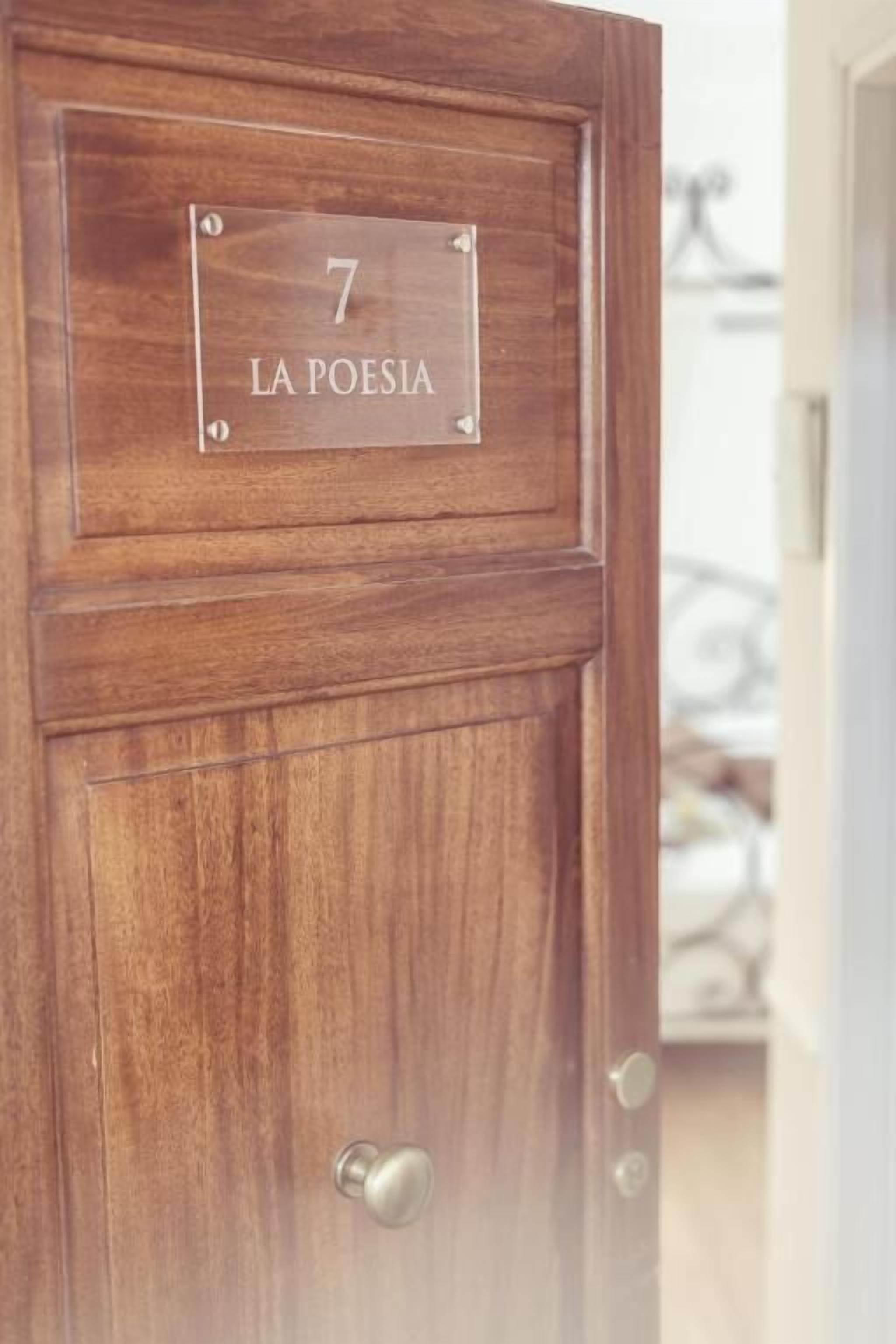 A wooden door with a plaque reading '7 LA POESIA'.