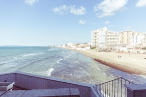 A coastal hotel with a beach view, a promenade, and high-rise buildings in the background. - Piccolo Mondo Hotel (Follonica)