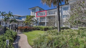 A residential building with a pathway, greenery, and a fenced area. - Resort Apartment 5302 at Gunnamatta Avenue (Kingscliff)