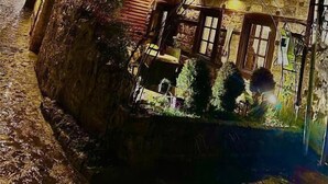 A traditional building with a balcony, stone walls, and a small garden area.