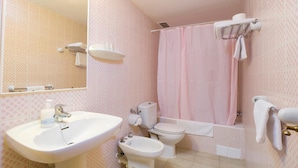Un bagno con lavandino, WC, bidet e tenda doccia.