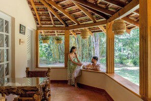 A room with a wooden ceiling, large windows, and a view of the outdoors.