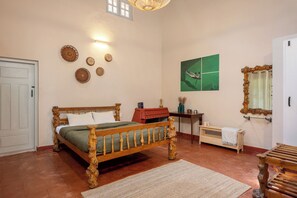 A bedroom with a wooden bed, a bedside table, a mirror, and wall decorations.