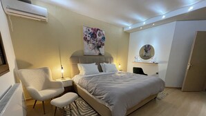 Una camera da letto moderna con un letto grande, una sedia, una scrivania e un armadio.