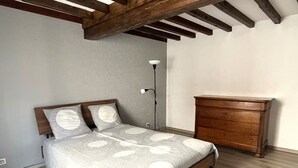 A bedroom with a wooden bed, a dresser, and a floor lamp.
