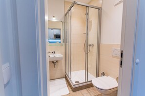 Ein Badezimmer mit Duschkabine, Waschbecken und Toilette.