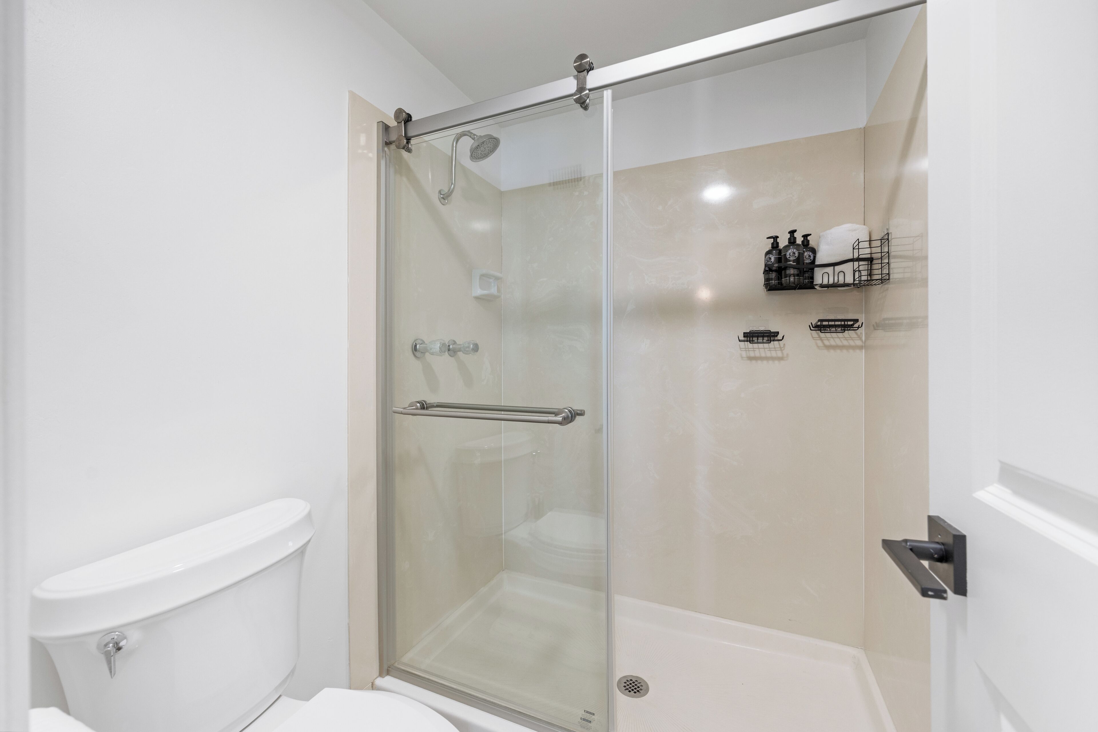 Une salle de bain moderne avec une douche à parois de verre, des toilettes et une baignoire.