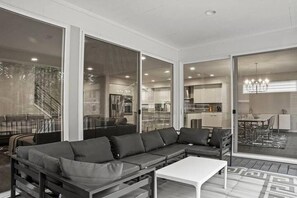 A modern living room with a sectional sofa, a coffee table, and large sliding glass doors leading to a balcony.