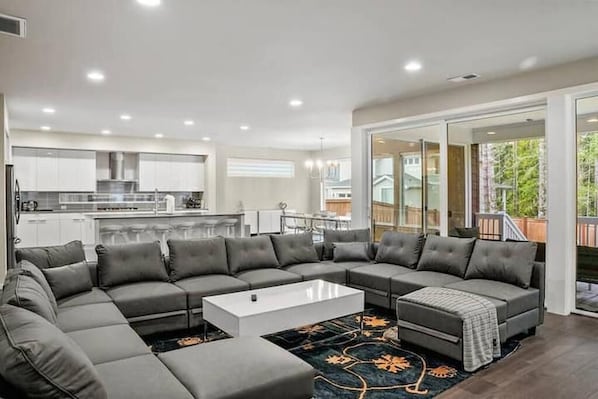 A modern living room with a sectional sofa, a coffee table, and a patterned rug.