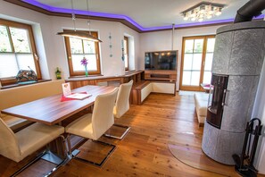 Eine moderne Küche mit eingebautem Herd, Holzboden und einer Essecke mit Tisch und Stühlen.