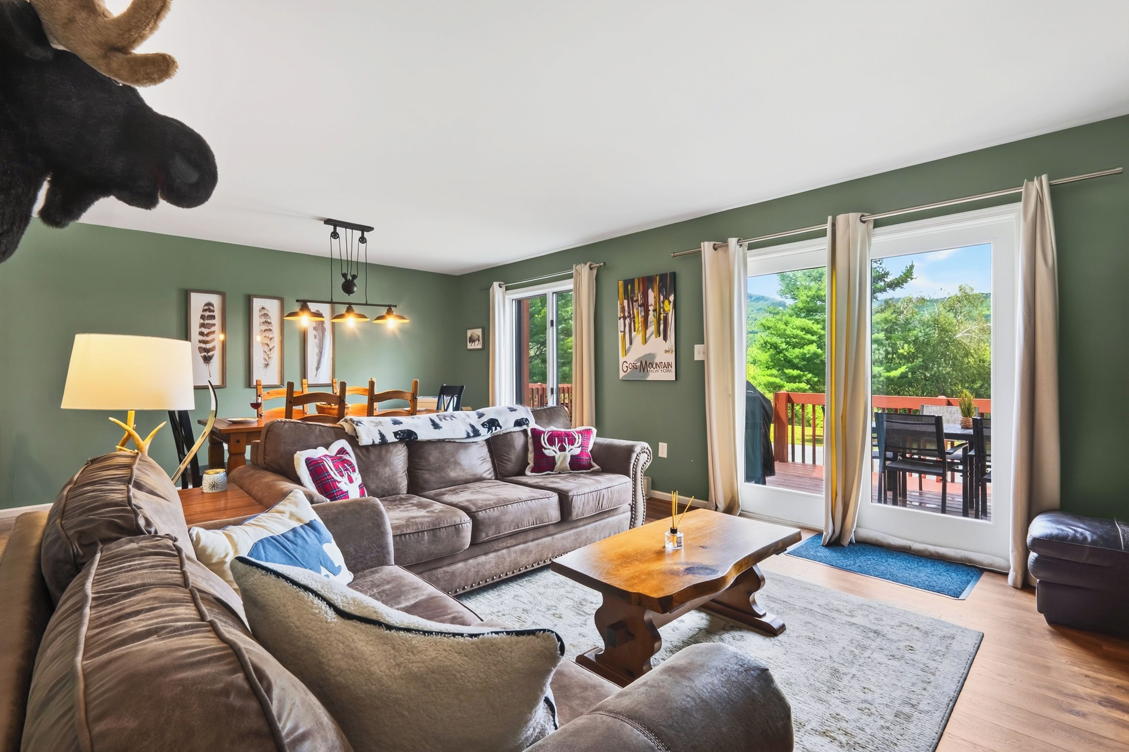 A cozy living room with a sectional sofa, a coffee table, and a dining area with a table and chairs.