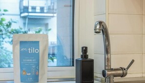 A window with a view of buildings, a modern faucet, and a cleaning kit bag. - Porta Vittoria Free Wifi & Netflix By TILO (Milan)