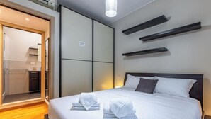Ett hotellrum med en säng, en garderob och en spegel.