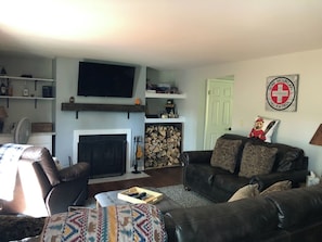 A living room with a fireplace, a television mounted on the wall, a sofa, and a coffee table.