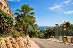 Camí costaner amb un senyal de límit de velocitat, un pas de vianants i vista al mar.