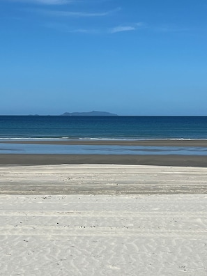 A beach with a clear sky and calm sea.