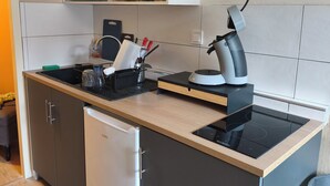 A modern kitchen with a built-in dishwasher, a coffee machine, and a kettle on the countertop. - Lovely 2-bedroom apartment in Saint-Didier-en-Velay perfect for relaxing (Saint-Didier-en-Velay)