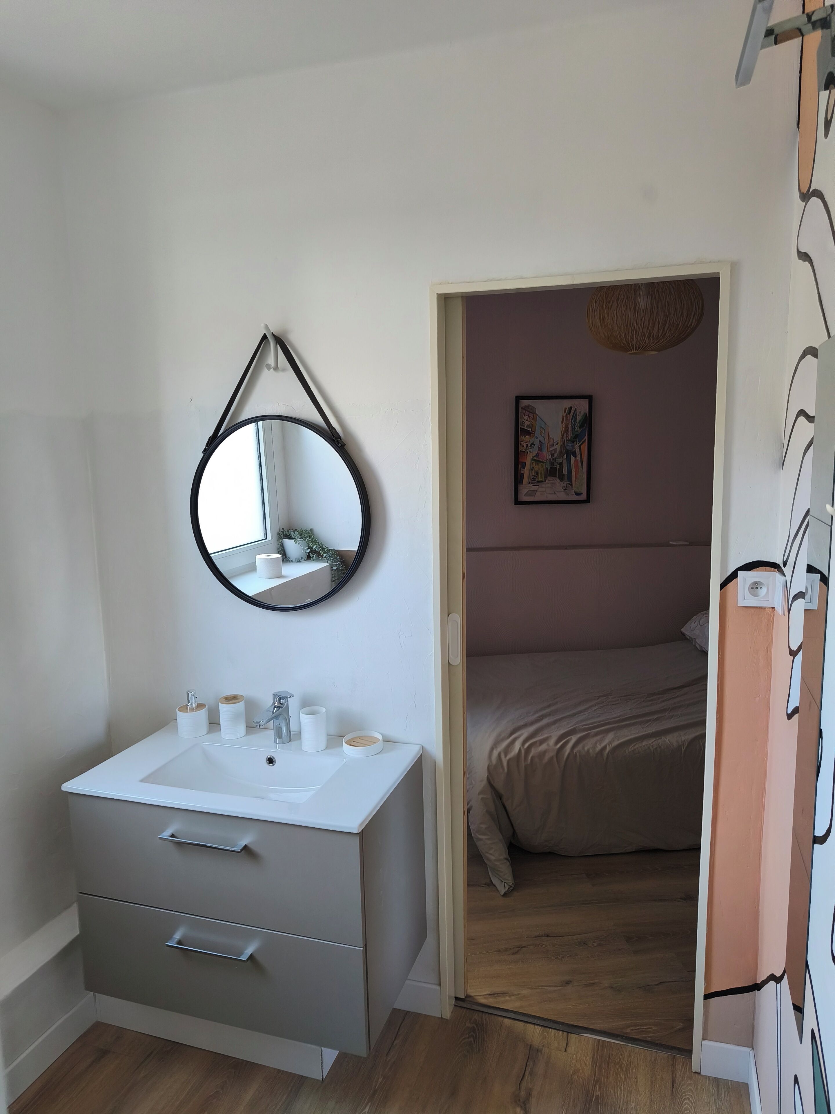 Een badkamer met een wit wastafelmeubel, een spiegel en twee lades.