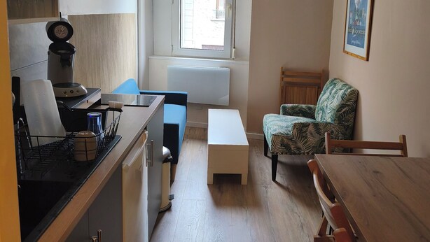 A compact living space with a kitchenette, a dining area, a window with a view, and a small seating area. - Lovely 2-bedroom apartment in Saint-Didier-en-Velay perfect for relaxing (Saint-Didier-en-Velay)