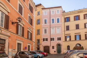 A narrow street with multi-story buildings, parked cars, and a visible sign indicating a no parking zone. - Farnese Wonderful Terrace (Roma)