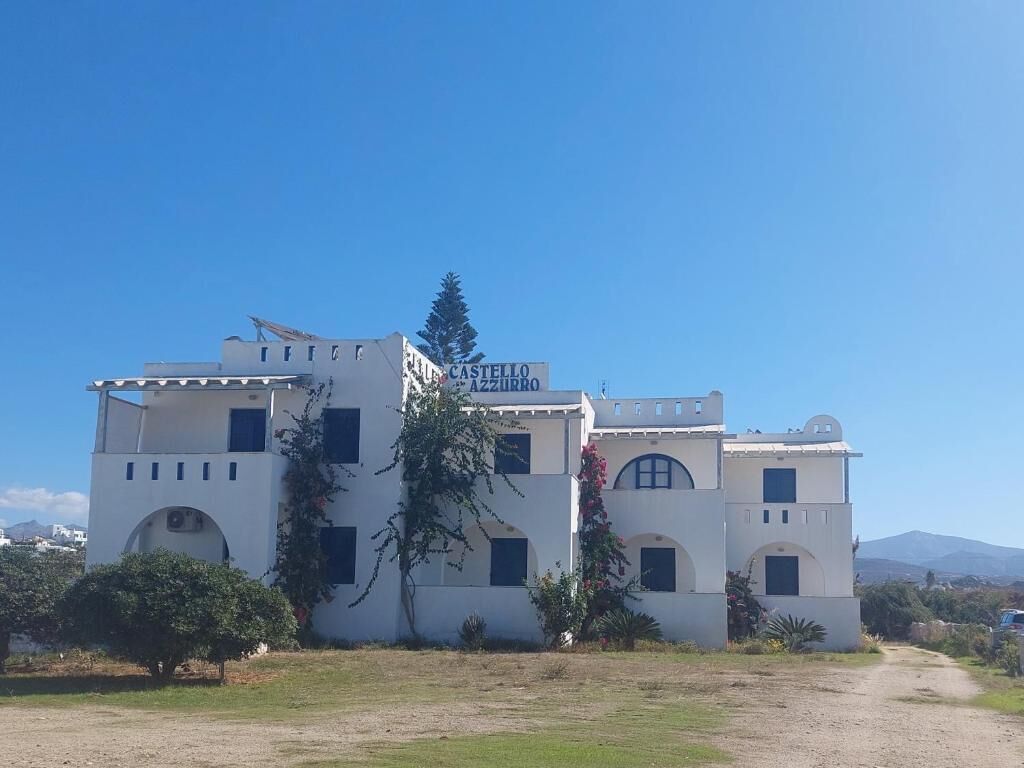 A white building with a sign reading 'CASTELLO AZZURRO.'