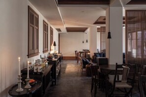 A hallway with a dining area, wooden furniture, and a lit candle on a table. - MistyHues DawnGreen (Lijiang)