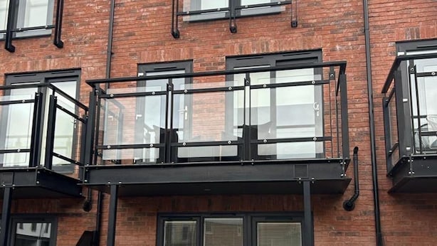 A multi-story brick building with a balcony, a gated entrance, and a sign indicating '48 RI ANKET.' - House Sleeps 5 With Balcony (Hull)