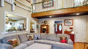 A living room with a sectional sofa, a wooden floor, a staircase, and a dining area. - On Horse Farm! Home w/ Gazebo in Aiken (Aiken)