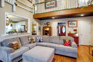 A living room with a sectional sofa, a wooden floor, a staircase, and a dining area. - On Horse Farm! Home w/ Gazebo in Aiken (Aiken)