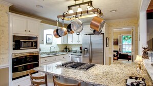 A kitchen with white cabinetry, a granite countertop, a stainless steel refrigerator, and a gas stove. - On Horse Farm! Home w/ Gazebo in Aiken (Aiken)