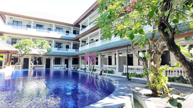 A multi-story hotel with a central swimming pool, balconies, and lush greenery. - Casa Mysa Hotel Kuta (Kuta)