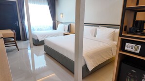 A hotel room with two beds, a desk, a chair, a coffee machine, and a safe. - Casa Mysa Hotel Kuta (Kuta)