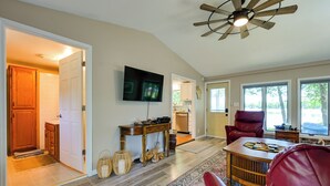 A spacious living room with a ceiling fan, a television, and a red leather chair. - Waterfront Days, Fireside Nights! Lake Helen Haven (Rosholt)