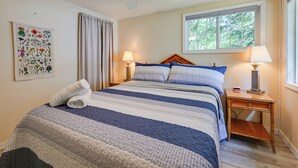 A bedroom with a bed, two bedside lamps, a window, a ceiling fan, and a botanical print on the wall. - Waterfront Days, Fireside Nights! Lake Helen Haven (Rosholt)