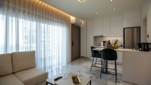 Un salon moderne comprenant un canapé, une table basse et un coin cuisine avec une table à manger et des chaises.
