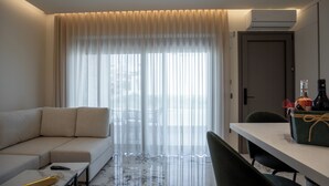 Une chambre d’hôtel moderne équipée d’un canapé, d’une table à manger et d’une chaise.