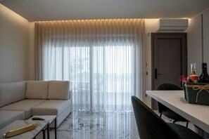 Ein modernes Hotelzimmer mit einer Couch, einem Esstisch und einem Stuhl.