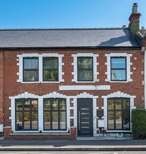 A two-story brick building with a central entrance, large windows, and a chimney. - Wimbledon Tennis - 3BR/2BA clean modern apartment with 1GB Wi-Fi and local host (London)