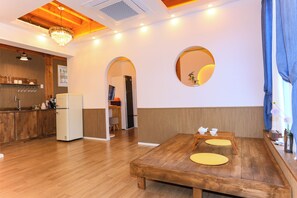 Una cocina moderna con armarios de madera, un refrigerador blanco y un comedor con mesa de madera y caminos de mesa amarillos.