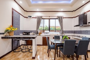 Una cocina moderna con comedor, ventanas amplias y vistas al exterior.