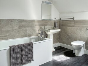 Ein modernes Badezimmer mit Badewanne, Waschbecken und Toilette.