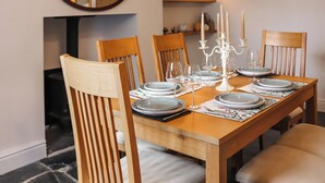 Une table à manger dressée avec des assiettes, des verres et un chandelier.