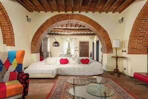 Ein Schlafzimmer mit zwei Betten, einem Glastisch und einem gemusterten Teppich.