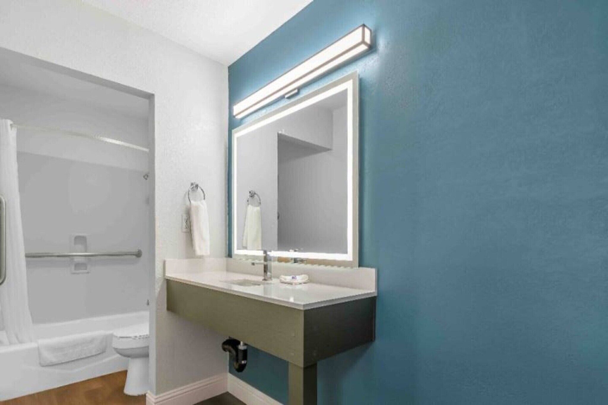 Un bagno con una vasca, un lavandino e uno specchio.