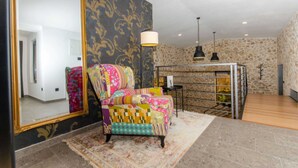 A room with a large mirror, a colorful armchair, a fireplace, and a stone wall. - Villa sa bazenom i jacuzzijem u Dalmatinskoj zagori na 20 min od Splita (Biorine)