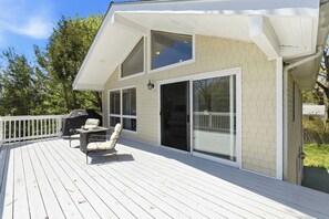 Una casa con terraza, asador y un patio cubierto.